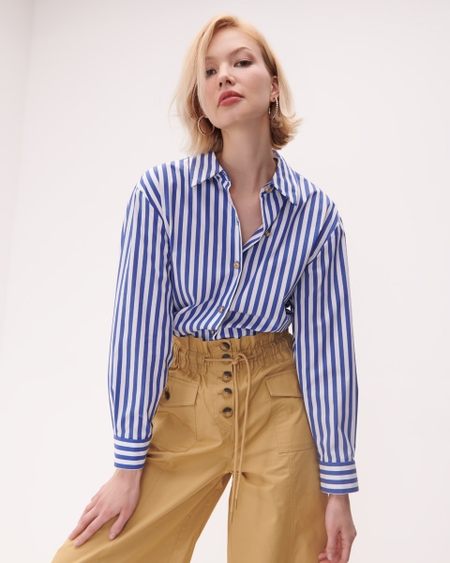 Camisa Azul A Rayas  <p>Una prenda que no puede faltar en tu clóset es esta camisa azul a rayas. Ideal para la oficina o salidas casuales. Úsala con pantalones formales y tacones para un look profesional. Proyectarás un estilo pulido y versátil.</p>
<tab